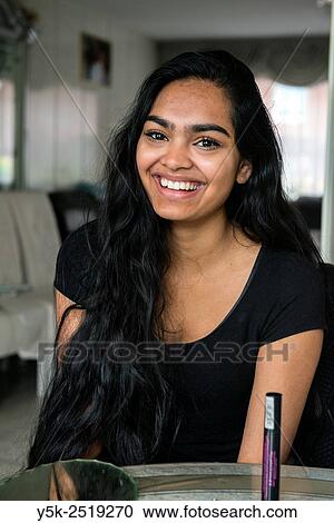 Rotterdam, Netherlands. Young, attractive Hindustani woman, giving a big smile while having a conversation in her kitchen. View Large Photo Image Stock Image - Rotterdam, Netherlands. Young, attractive Hindustani woman, giving a big smile while having a conversation in her kitchen.. Fotosearch