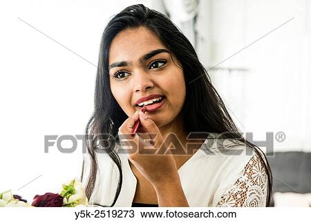 Rotterdam, Netherlands. Young, attractive Hindustani woman, at home applying makeup to her face. View Large Photo Image Stock Image - Rotterdam, Netherlands. Young, attractive Hindustani woman, at home applying makeup to her face.. Fotosearch