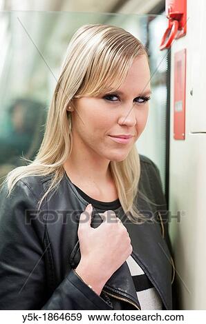 Stock Photo - Rotterdam, Netherlands. Young, fashionable blonde traveling by subway or underground.. Fotosearch