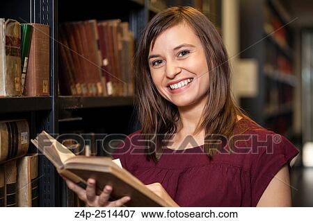 Student in library smiling into camera. View Large Photo Image Stock Photo - Student in library smiling into camera.. Fotosearch
