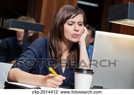 Stock Image - Student learning in library. Fotosearch