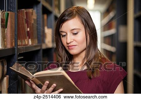 Student reading a book in library View Large Photo Image Stock Photograph - Student reading a book in library. Fotosearch
