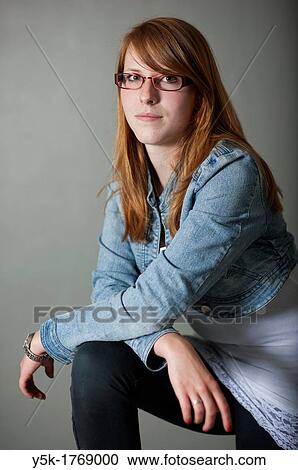 Studio-portrait of a redheaded, young woman with glasses against a grey background. View Large Photo Image Stock Image - Studio-portrait of a redheaded, young woman with glasses against a grey background.. Fotosearch