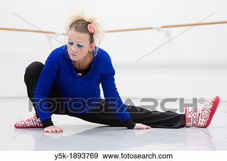 Tilburg, Netherlands. A professional dancer and choreographer of modern dance busy stretching and straightening her muscles before a rehearsal of improvised, modern dance. View Large Photo Image Stock Photo - Tilburg, Netherlands. A professional dancer and choreographer of modern dance busy stretching and straightening her muscles before a rehearsal of improvised, modern dance.. Fotosearch