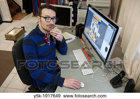 Tilburg, Netherlands. Graphic designer and art director working on an assignment behind his desk with an Apple iMac computer. View Large Photo Image Stock Photo - Tilburg, Netherlands. Graphic designer and art director working on an assignment behind his desk with an Apple iMac computer.. Fotosearch