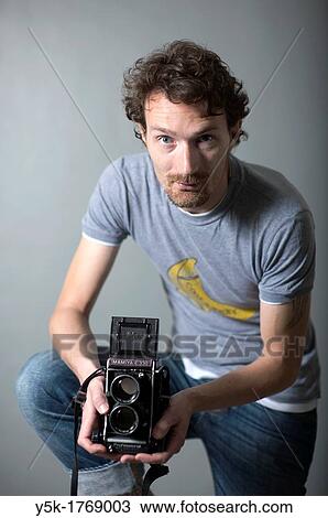 Tilburg, Netherlands. Man with a vintage medium format twin lens reflex camera. Studio-portrait against grey background. View Large Photo Image Stock Image - Tilburg, Netherlands. Man with a vintage medium format twin lens reflex camera. Studio-portrait against grey background.. Fotosearch