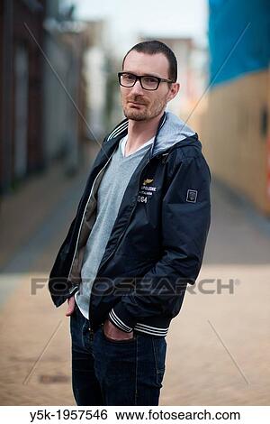 Stock Photograph - Tilburg, Netherlands. Street-portrait of a be-glassed young man.. Fotosearch