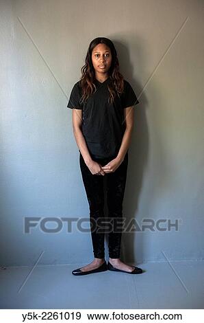 Tilburg, Netherlands. Studio shot of dark skinned woman from African decent standing against a grey, concrete wall in fist ballet position. View Large Photo Image Stock Photo - Tilburg, Netherlands. Studio shot of dark skinned woman from African decent standing against a grey, concrete wall in fist ballet position.. Fotosearch