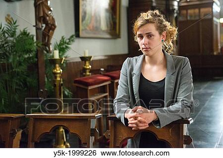 Tilburg, Netherlands. Young woman in the benches of a Roman Catholic Church, after her prayers to the eternal spirit. View Large Photo Image Stock Photograph - Tilburg, Netherlands. Young woman in the benches of a Roman Catholic Church, after her prayers to the eternal spirit.. Fotosearch