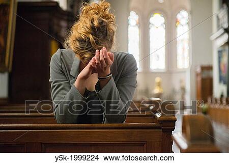 Tilburg, Netherlands. Young woman, praying to the eternal spirit, in the benches of a Roman Catholic Church. View Large Photo Image Picture - Tilburg, Netherlands. Young woman, praying to the eternal spirit, in the benches of a Roman Catholic Church.. Fotosearch