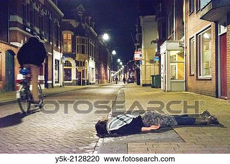 Tuinstraat, Tilburg, Netherlands. Woman in her thirties, lying flat on the pavements of the street at night. View Large Photo Image Stock Image - Tuinstraat, Tilburg, Netherlands. Woman in her thirties, lying flat on the pavements of the street at night.. Fotosearch