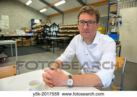 Stock Photo - Vught, Netherlands. Public Relation manager of a company for Artificial Insemination of farm animals explaining his company from the companies distribution centre.. Fotosearch