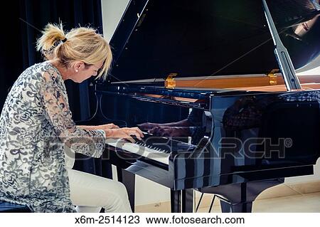 Stock Image - Woman playing the piano.. Fotosearch