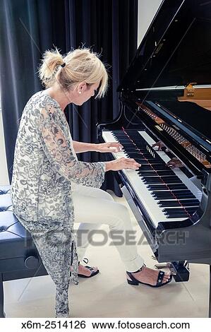 Stock Photograph - Woman playing the piano.. Fotosearch