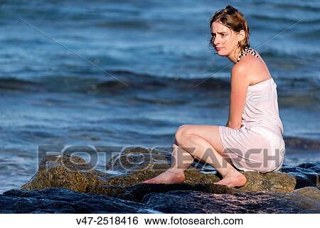 Woman sitting on a rock in a cove of Javea, Spain, Europe View Large Photo Image Stock Photograph - Woman sitting on a rock in a cove of Javea, Spain, Europe. Fotosearch