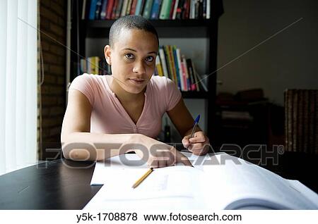 Young, African woman, making her home-work, while learning Dutch as a second language. View Large Photo Image Stock Photo - Young, African woman, making her home-work, while learning Dutch as a second language.. Fotosearch