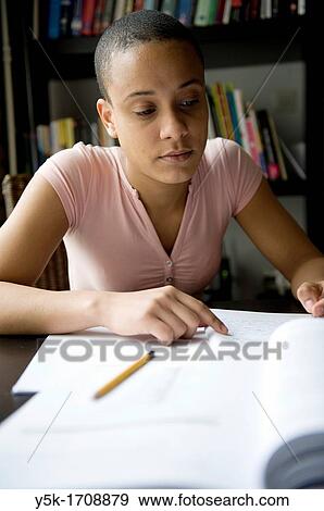 Young, African woman, making her home-work, while learning Dutch as a second language. View Large Photo Image Stock Photo - Young, African woman, making her home-work, while learning Dutch as a second language.. Fotosearch