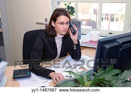 Young, attractive woman working in the office of a callcentre. View Large Photo Image Stock Photo - Young, attractive woman working in the office of a callcentre.. Fotosearch