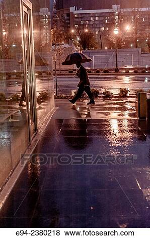 A partial view of a man carrying an umbrella on a city sidewalk on a rainy morning. View Large Photo Image Stock Photo - A partial view of a man carrying an umbrella on a city sidewalk on a rainy morning.. Fotosearch