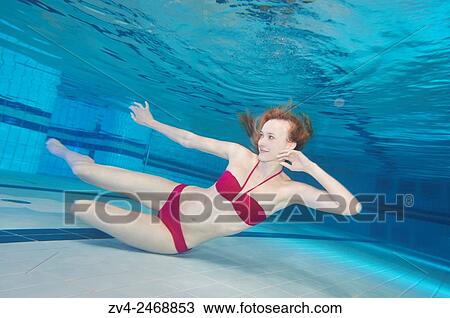 Stock Image - A young woman under water in swimsuit. Fotosearch