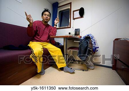 An Indonesian seaman or sailor on the container-vessel MV Flintercape, during a journey from Rotterdam, Netherlands, to Sundsvall, Sweden. The man is an ´Able Seaman´, who generally works on deck, and now prepares for the night in his cabin. View Large Photo Image Stock Image - An Indonesian seaman or sailor on the container-vessel MV Flintercape, during a journey from Rotterdam, Netherlands, to Sundsvall, Sweden. The man is an ´Able Seaman´, who generally works on deck, and now prepares for the night in his cabin.. Fotosearch