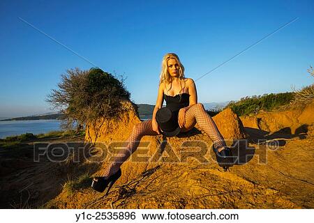Stock Photograph - Beautiful young woman in sunset light in wilderness.. Fotosearch