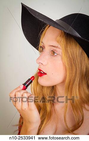 Blonde teenage girl applying lipstick. View Large Photo Image Stock Image - Blonde teenage girl applying lipstick.. Fotosearch