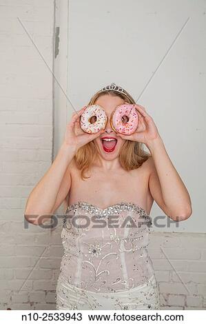 Blonde teenage girl looking through a pair of donuts. View Large Photo Image Stock Image - Blonde teenage girl looking through a pair of donuts.. Fotosearch