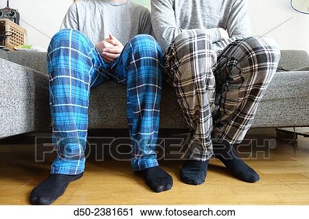 Stock Image - Brothers in pyjamas on couch, cozy Saturday, Stockholm, Sweden. Fotosearch