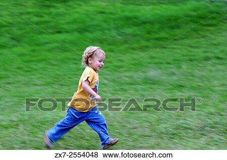 Stock Photo - Children running in the grass in Big Island, Hawaii. USA.. Fotosearch