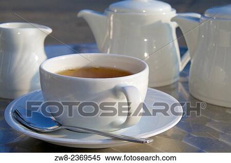 Stock Photography - Cup of tea and tea pot on stainless steal table.. Fotosearch