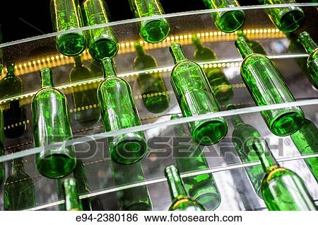 Stock Photograph - Empty green wine bottles on shelves in a bar.. Fotosearch