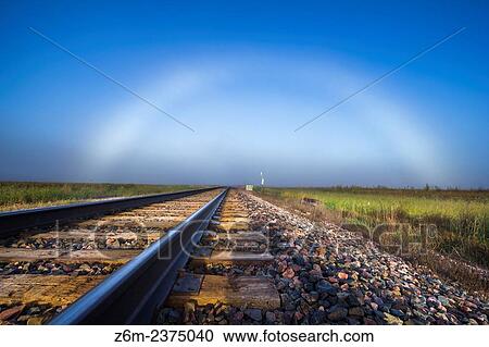 Stock Image - Fogbow forms in western Iowa over some train tracks.. Fotosearch