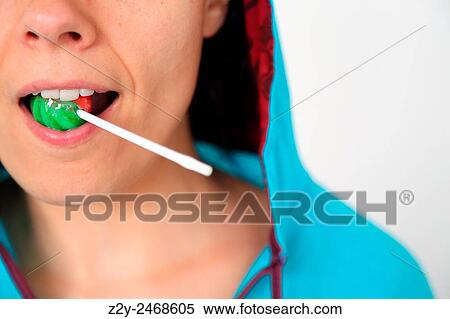 Girl holding a lollipop with her teeth. View Large Photo Image Stock Photography - Girl holding a lollipop with her teeth.. Fotosearch