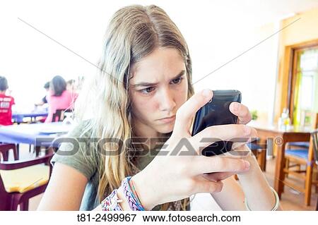 Girl looking at a mobile phone, Peñiscola, Spain View Large Photo Image Stock Photo - Girl looking at a mobile phone, Peñiscola, Spain. Fotosearch