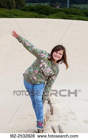 girl teetering on the sand of the beach. Cadiz, Andalusia, europe View Large Photo Image Stock Photo - girl teetering on the sand of the beach. Cadiz, Andalusia, europe. Fotosearch