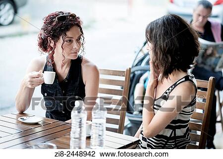 Stock Image - Girlfriends meet over coffee.. Fotosearch