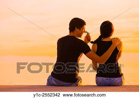 Happy teen couple in sunset he teases her View Large Photo Image Stock Image - Happy teen couple in sunset he teases her. Fotosearch