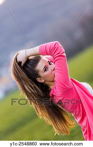 Stock Image - Looking back over shoulder female teenager. Fotosearch