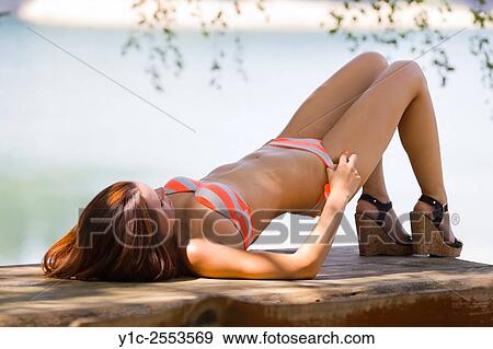 Lying atop wooden table young woman in bikini, removing panties View Large Photo Image Stock Photo - Lying atop wooden table young woman in bikini, removing panties. Fotosearch
