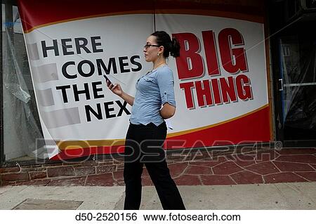 Main street. Storefront under construction. Woman passes by with cellphone. Torrington, Connecticut, USA View Large Photo Image Stock Photograph - Main street. Storefront under construction. Woman passes by with cellphone. Torrington, Connecticut, USA. Fotosearch