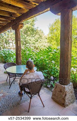 Stock Photo - Man sitting in a terrace in a rural hotel. Segovia province, Castilla Leon, Spain.. Fotosearch