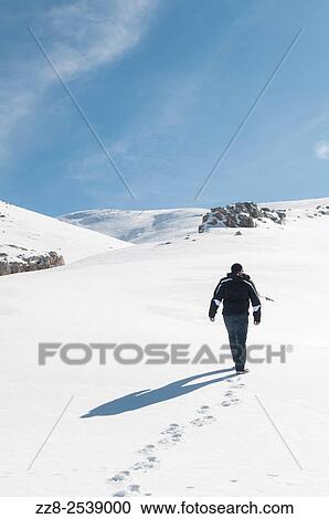 Stock Image - Man walking in the snow Faraya Lebanon. Fotosearch