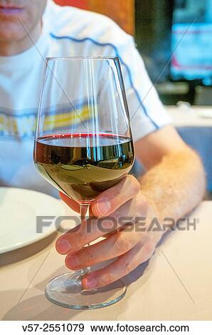 Man's hand holding a glass of red wine. Close view. View Large Photo Image Stock Photo - Man's hand holding a glass of red wine. Close view.. Fotosearch