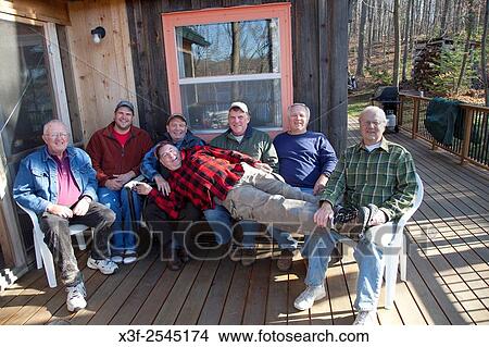 Picture - Men´s weekend woodchopping encounter group enjoying a moment before starting work. Cumberland Wisconsin WI USA.. Fotosearch