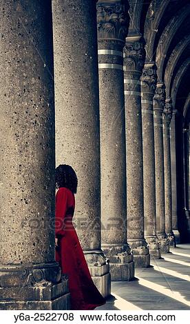 Mysterious woman in red dress behind column. View Large Photo Image Stock Photo - Mysterious woman in red dress behind column.. Fotosearch