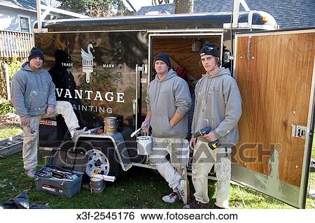 Stock Photograph - Portrait of house painters standing in front of their supply trailer with paint and tools. St Paul Minnesota MN USA.. Fotosearch