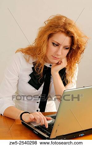 Redhaired young woman working with a computer. View Large Photo Image Stock Photo - Redhaired young woman working with a computer.. Fotosearch
