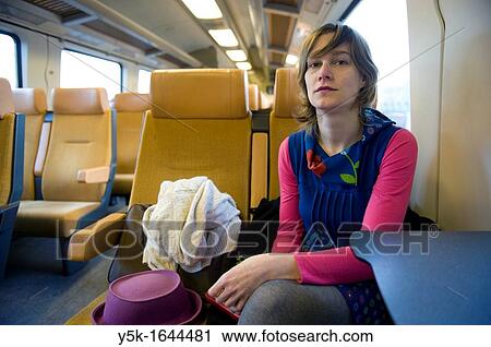Rotterdam, Netherlands. A young, attractive woman, in colorfull wardrobe, traveling by intercity train from Rotterdam to Breda. View Large Photo Image Stock Image - Rotterdam, Netherlands. A young, attractive woman, in colorfull wardrobe, traveling by intercity train from Rotterdam to Breda.. Fotosearch