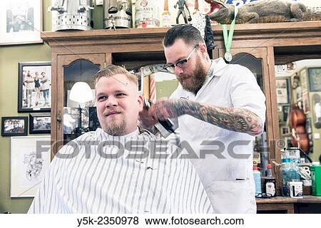 Rotterdam, Netherlands. Barber store Schorem. Barber helping his customer in his barber shop by cutting and modeling his hair. View Large Photo Image Stock Photo - Rotterdam, Netherlands. Barber store Schorem. Barber helping his customer in his barber shop by cutting and modeling his hair.. Fotosearch